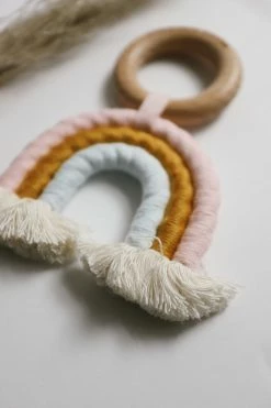 CHEWABLE CHARM LIFESTYLE RAINBOW MACRAME TEETHER · PINK + BLUE